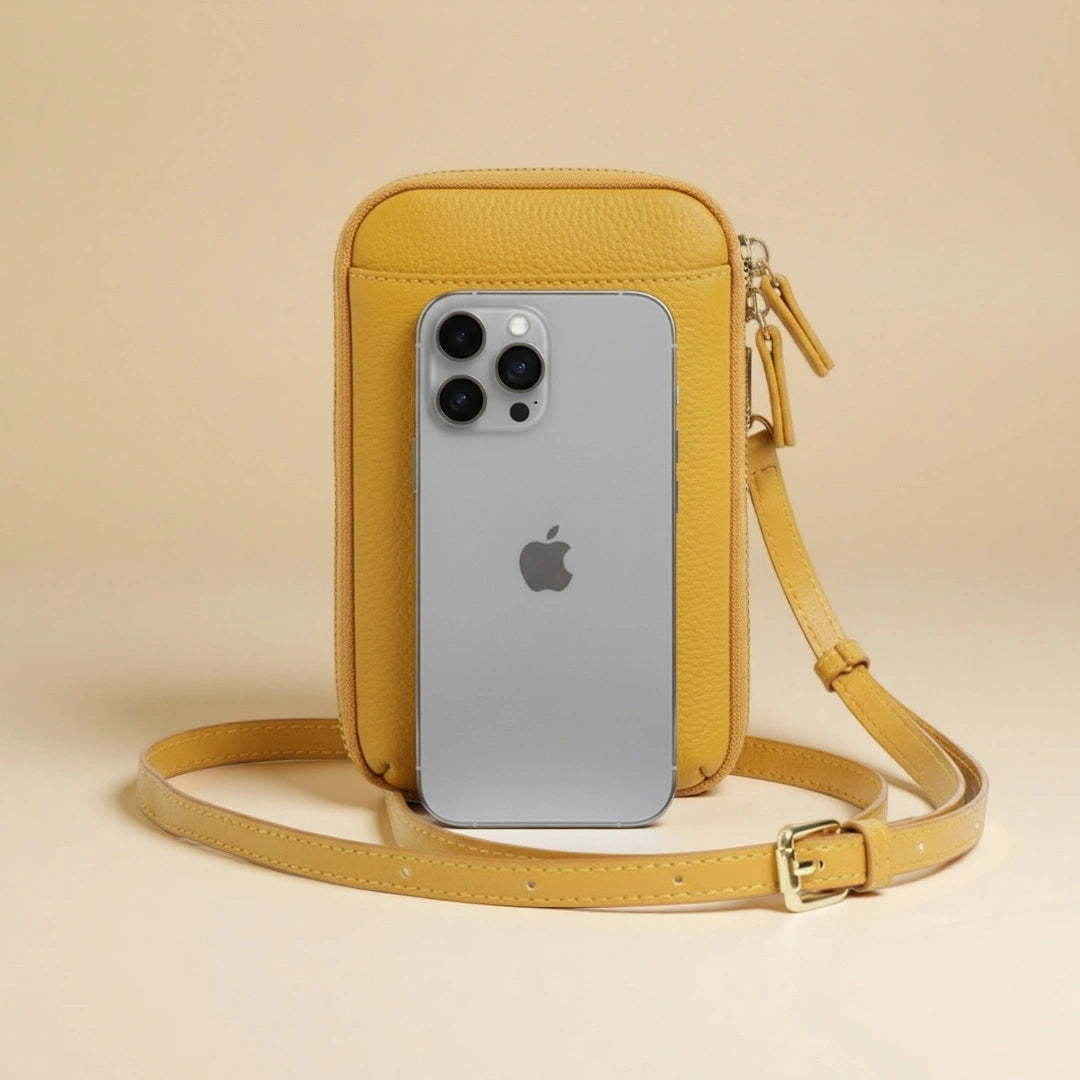 Yellow crossbody bag with an iPhone inside on a beige background