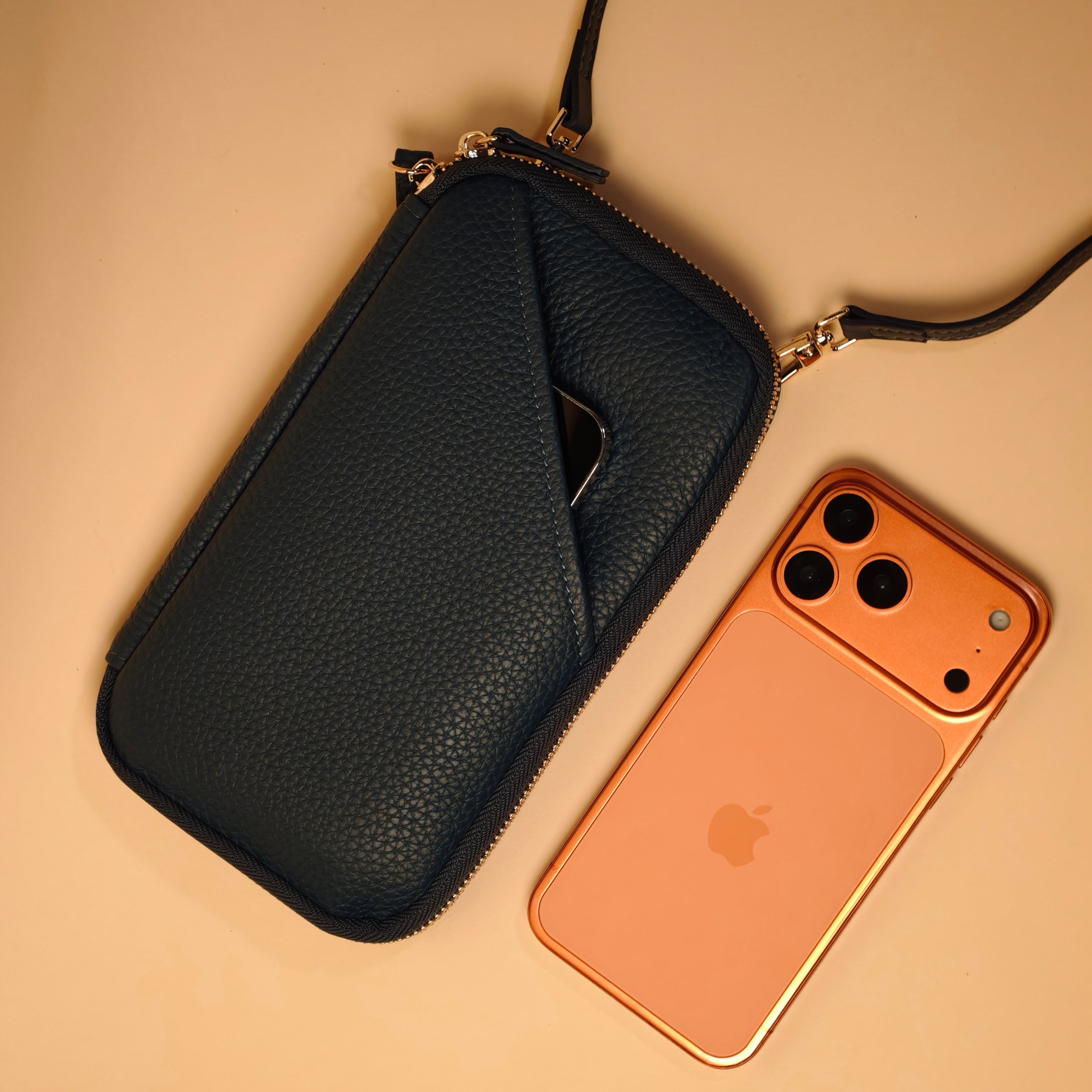 Black leather pouch with a phone on a beige background